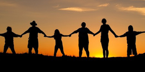 people holding hands at sunset